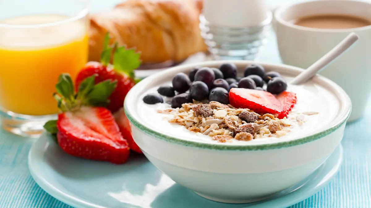 Ein gesundes Frühstück mit Müsli mit Joghurt, Obst, gekochtem Ei und Orangensaft